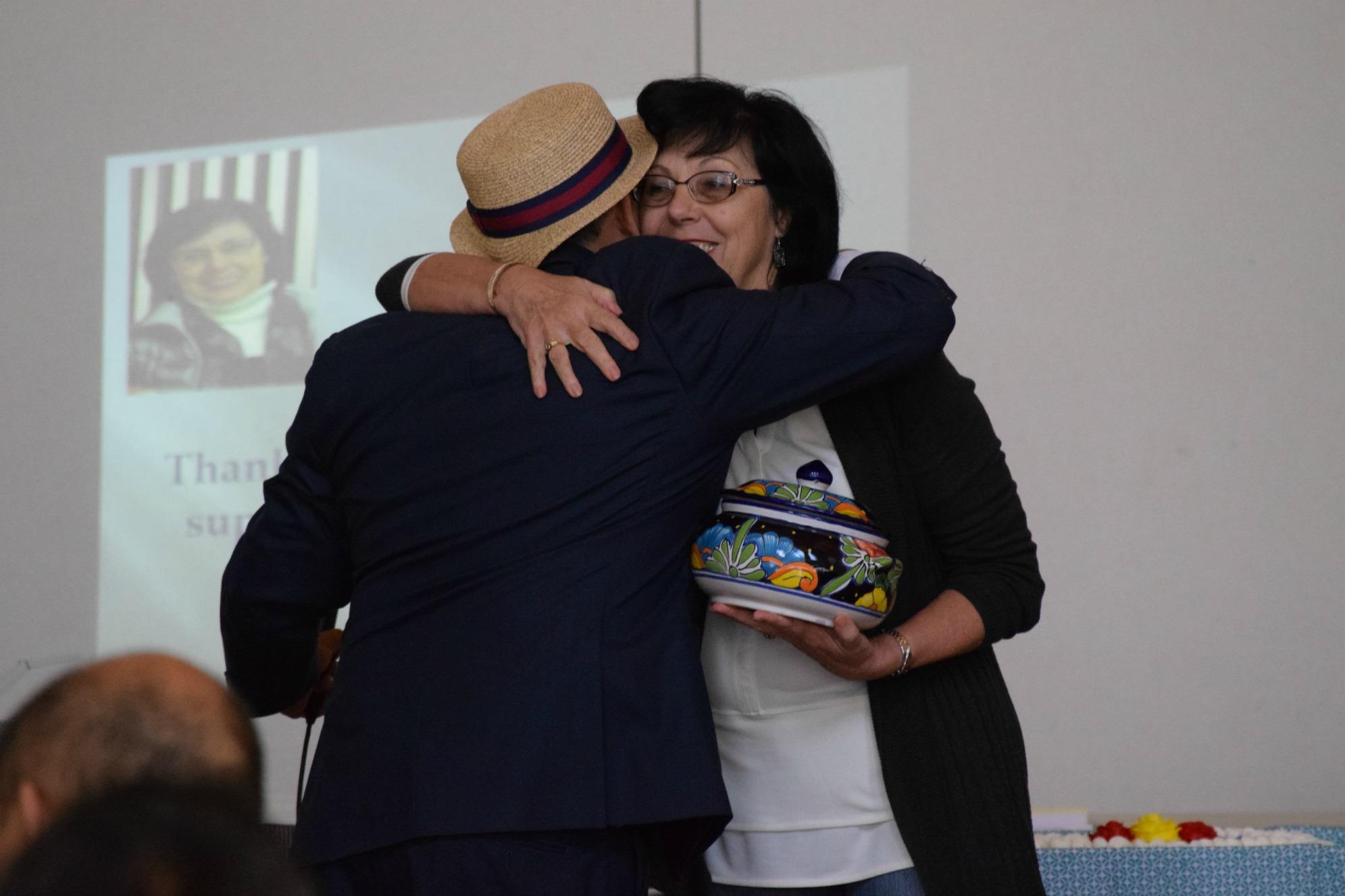 Former Associate Superintendent Brigitte Sarraf, who supported the Latino community during her 47 years with the district, receives a gift of appreciation from counselor Ariel Rojas during the Latino summit. Photo by Francesca Fallow.