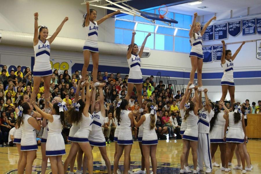 The varsity cheer team performs during the back-to-school assembly. The team works hard to represents the school both at various athletic events and cheer-specific competitions. Photo by Kunal Pandit.
