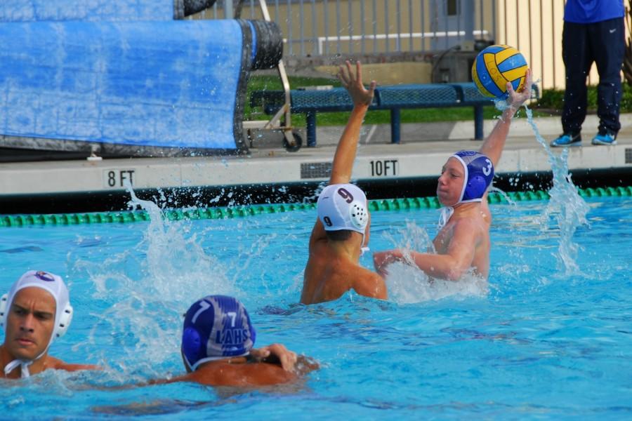 Junior Ryan Fisse tries to pass a defender.  The boys water polo team is looking to end the season strong and make a deep run in playoffs. Photo by Francesca Fallow.