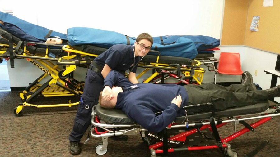 Senior+Marshall+Scott+poses+over+a+fellow+EMR+on+a+stretcher.+Working+as+an+EMR+allows+Marshall+to+pursue+his+passion+for+helping+others.+Photo+courtesy+Marshall+Scott.