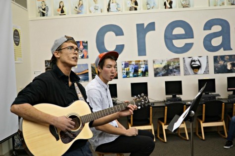 Juniors Viktor Niemiec (left) and Derek Mark (right) perform at the Open Mic Night in the library. Viktor sings and plays the guitar, while Derek beatboxes. Photo by Michael Sieffert. 