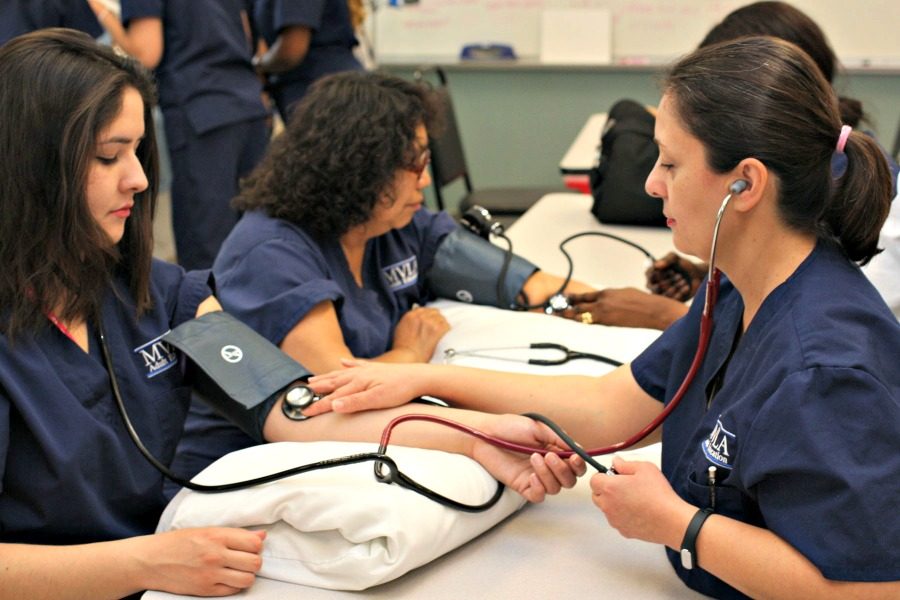 Teresa (left) practices taking blood pressure and pulse with a peer. While still a student at LAHS, Teresa attends nursing classes and holds a part time job. Photo courtesy Teresa Casillas. 