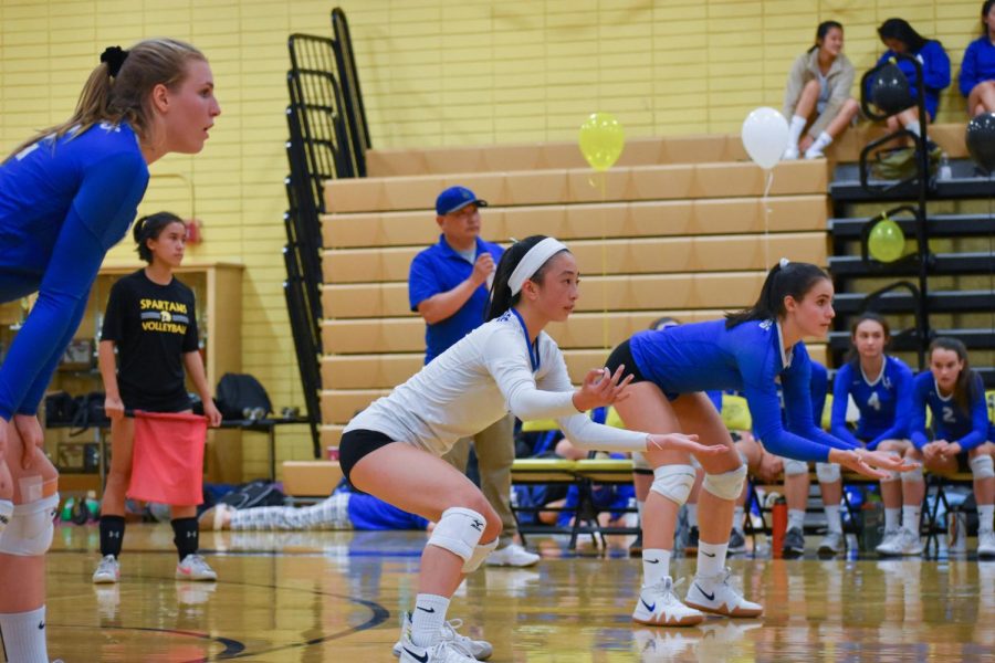 Libero Kaitlyn Wong prepares for Mountain Views serve. The varsity volleyball team won 3-0 against Mountain View, and secured their number two standing in leagues.