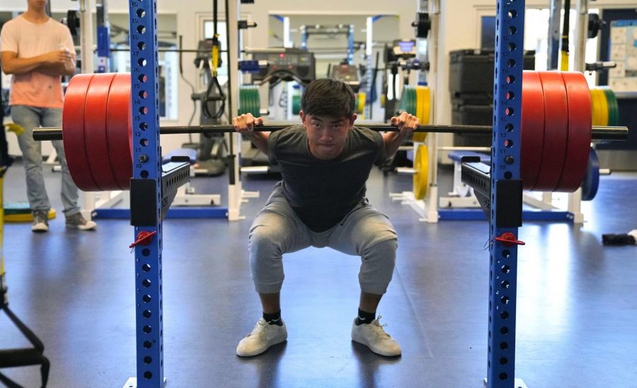 Junior Jiayan Luo does a squat, lifting a 142-kilogram (315 pound) barbell in the Fitness Center. Jiayan set his personal record of 155 kilograms (355 pounds) for the squat at nationals after qualifying for the tournament this past February.