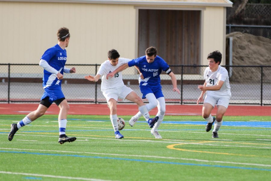 Senior Harry Allen fights a Palo Alto player for the ball. Varsity boys soccer placed fifth in the league and qualified for CCS, but were pulled out by administration.