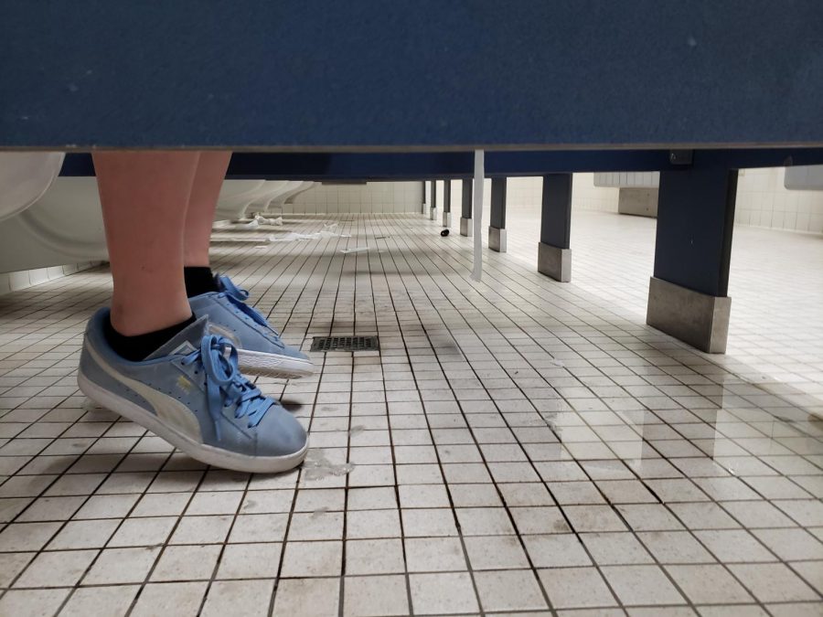 Isabella Borkovic hesitates to place her shoes on the dirty and wet bathroom floor.