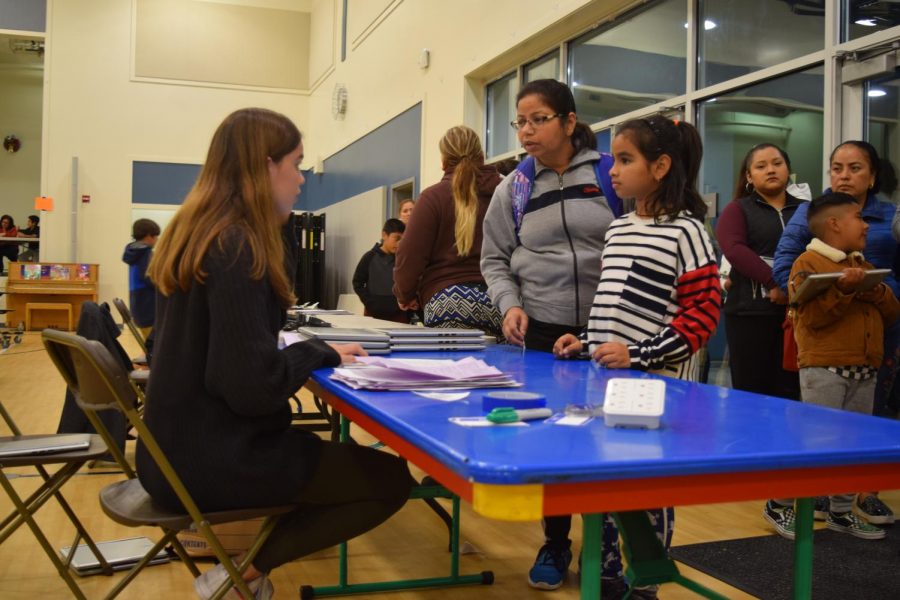 EqOpTech club member sophomore Sofia Mujica gives a student a refurbished laptop at Castro Elementary. EqOpTech, a club at Los Altos, provides free laptops to students who cant afford them. 