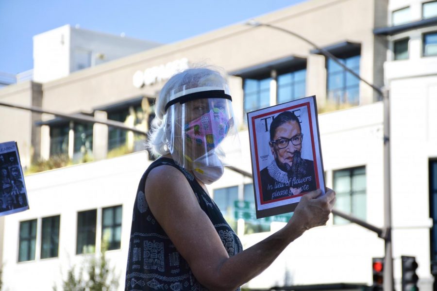 A protester honors the late Ruth Bader Ginsburg. At todays rally in San Mateo, many held picket signs denouncing Donald Trump and Amy Coney Barrett.