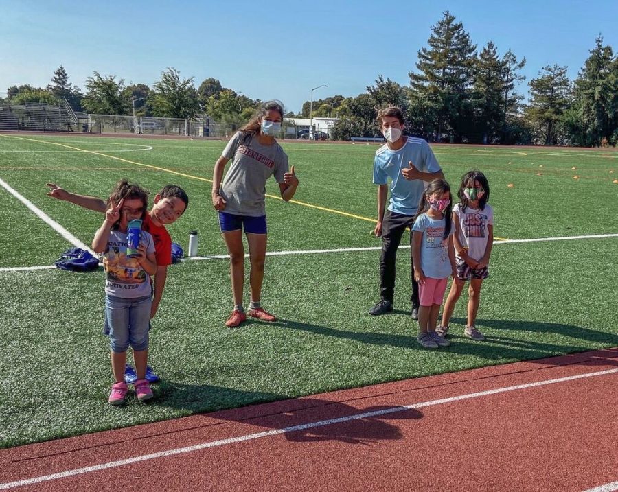 Juniors Allan Feldman and Esha Gupta pose with kids attending their sports clinic, AE Soccer Training. After seeing sports camps shut down due to the COVID-19 pandemic, four LAHS students decided to create safe sports clinics to benefit young athletes around the Bay Area.