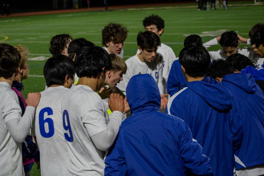 The Los Altos High School varsity boys soccer team huddles during halftime at Mountain View High School.