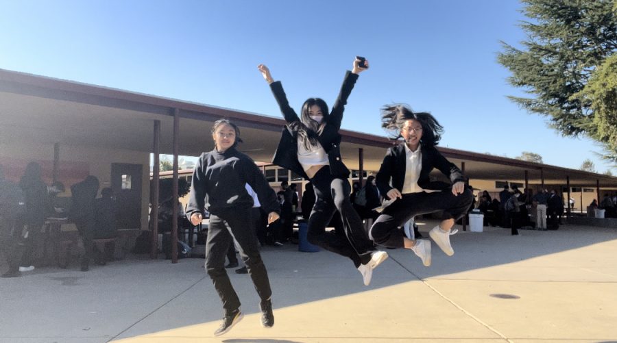 Three debaters at Coast Forensic League Superdebate jump for a picture.