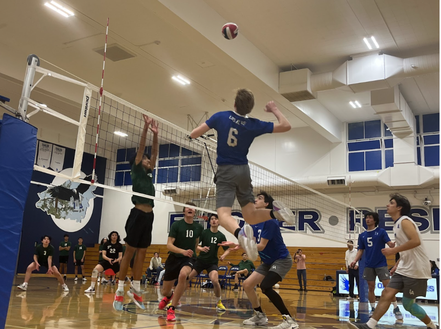 Junior+outside+hitter+Aidan+Cuppett+takes+a+swing%2C+surrounded+by+his+teammates+of+the+varsity+boys+volleyball+team.