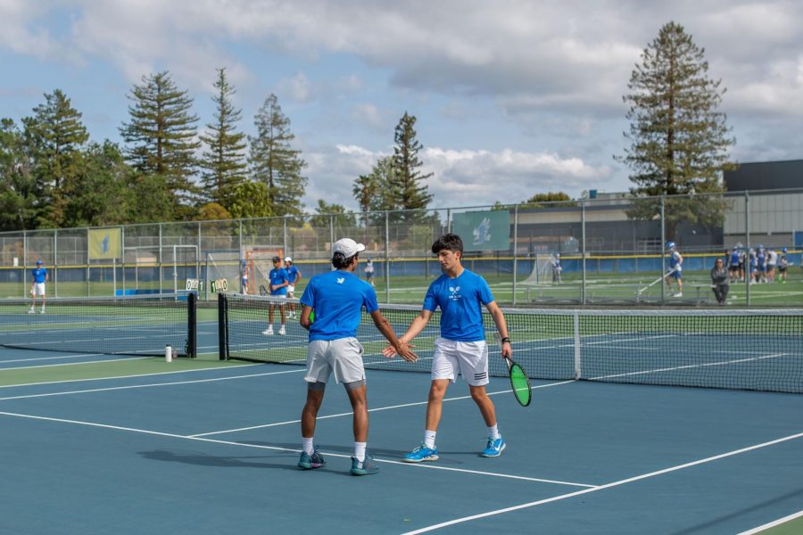 Junior Rohan Panchal and freshman Cyrus Ghaffari high-five after a doubles match. 