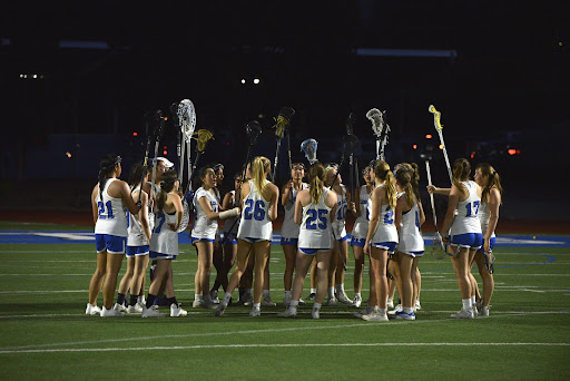 The Eagles gather around to celebrate their 19–4 win by raising their sticks.