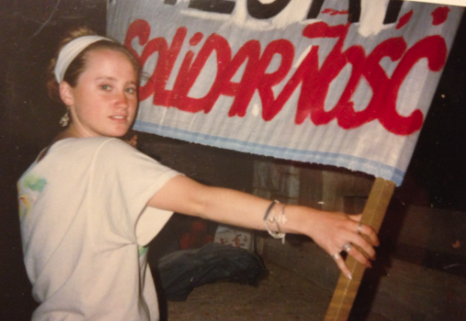 Safian in her early twenties in Poland, holding a poster reading “Solidarność,” the name of the grassroots organization that she volunteered for.