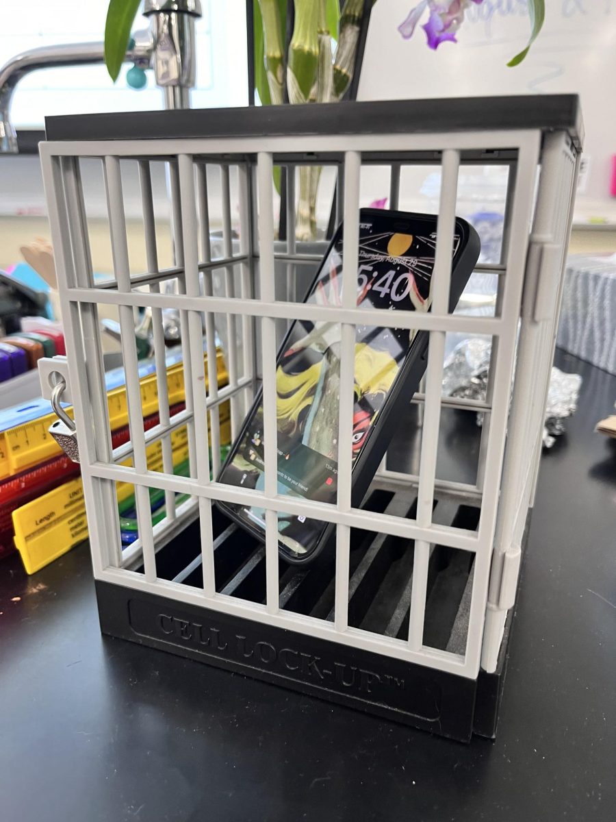 Teachers have been implementing more restrictive phone policies. Photo illustration of student phone in “phone jail” during class time. 