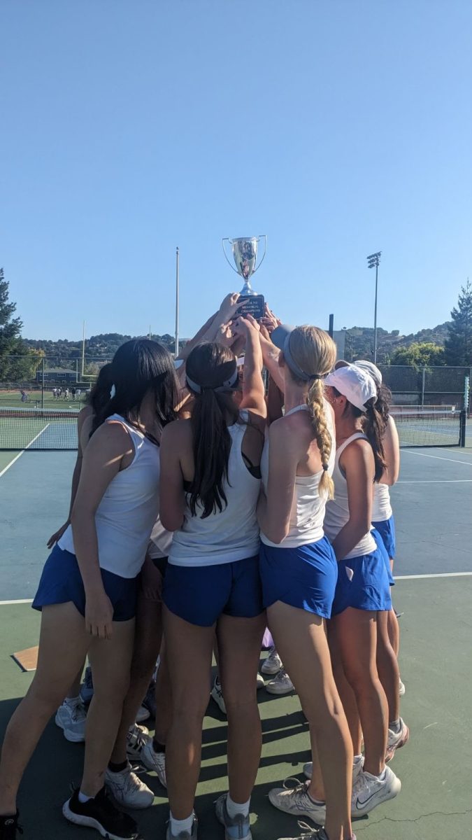 Varsity girls tennis hoists up Tyler Nii Memorial Cup trophy after defeating the Menlo Atherton Knights