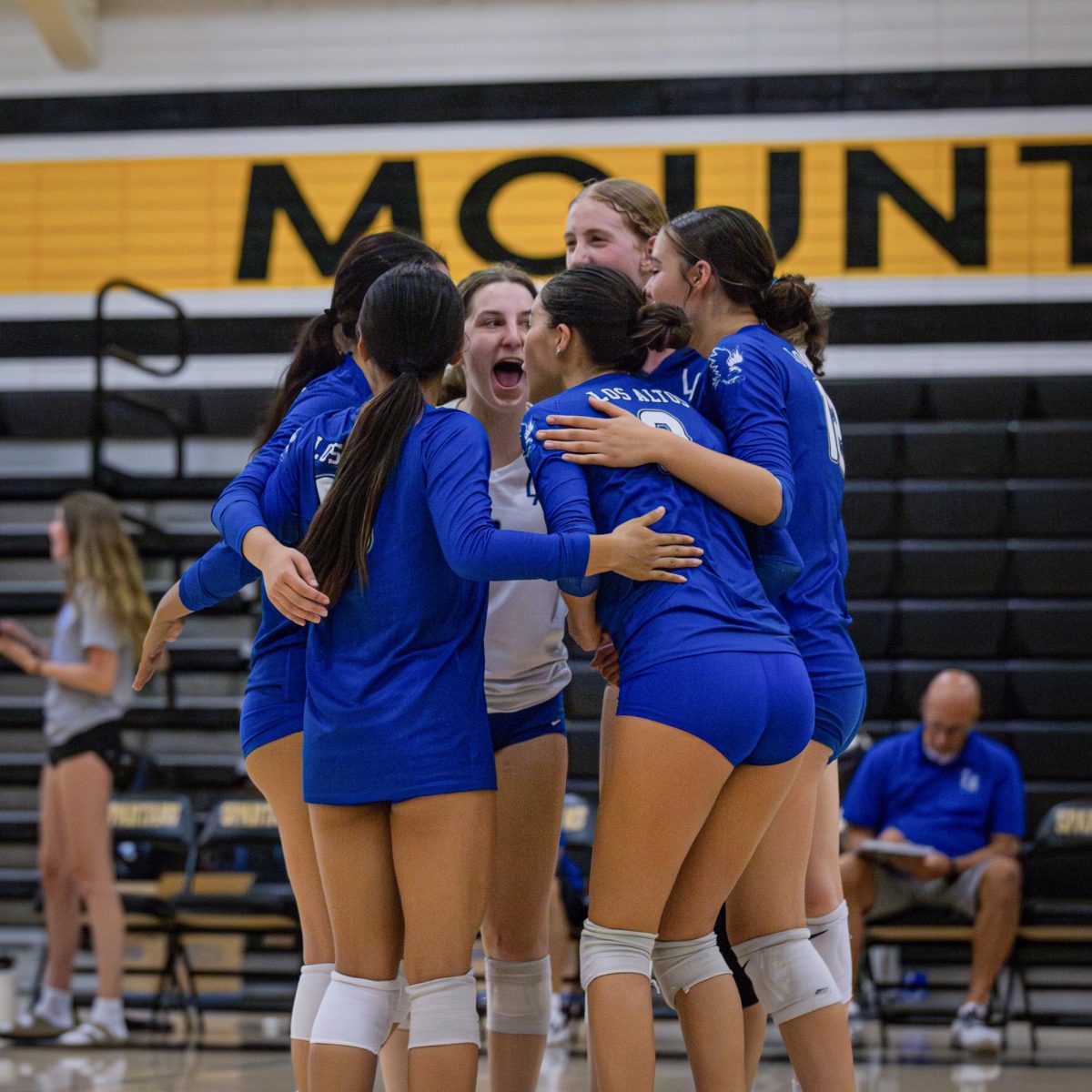 The Los Altos High School varsity girls volleyball team celebrates together after winning a point.