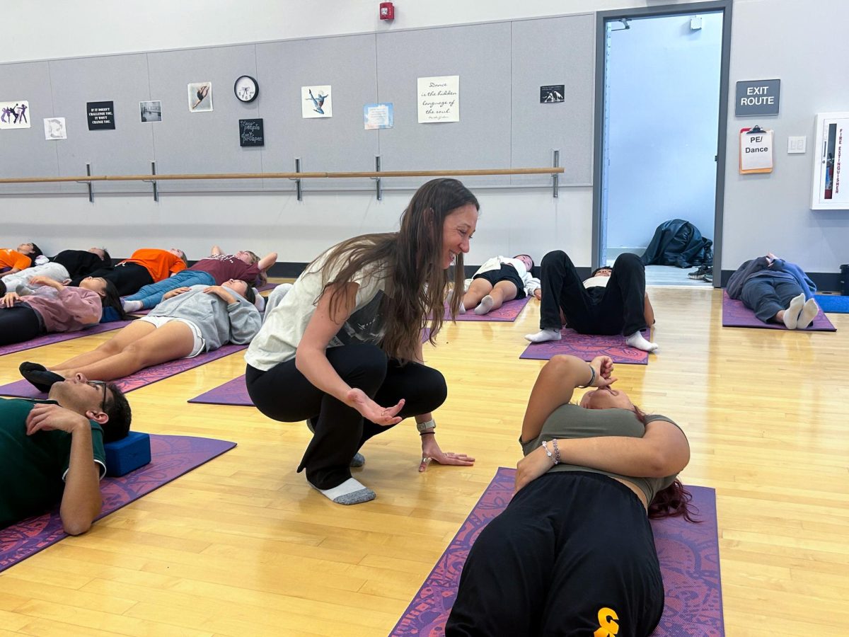 Carrie Abel Shaffer gives a yoga student feedback on her pose. Abel introduced yoga classes to Los Altos High School to promote mindfulness.