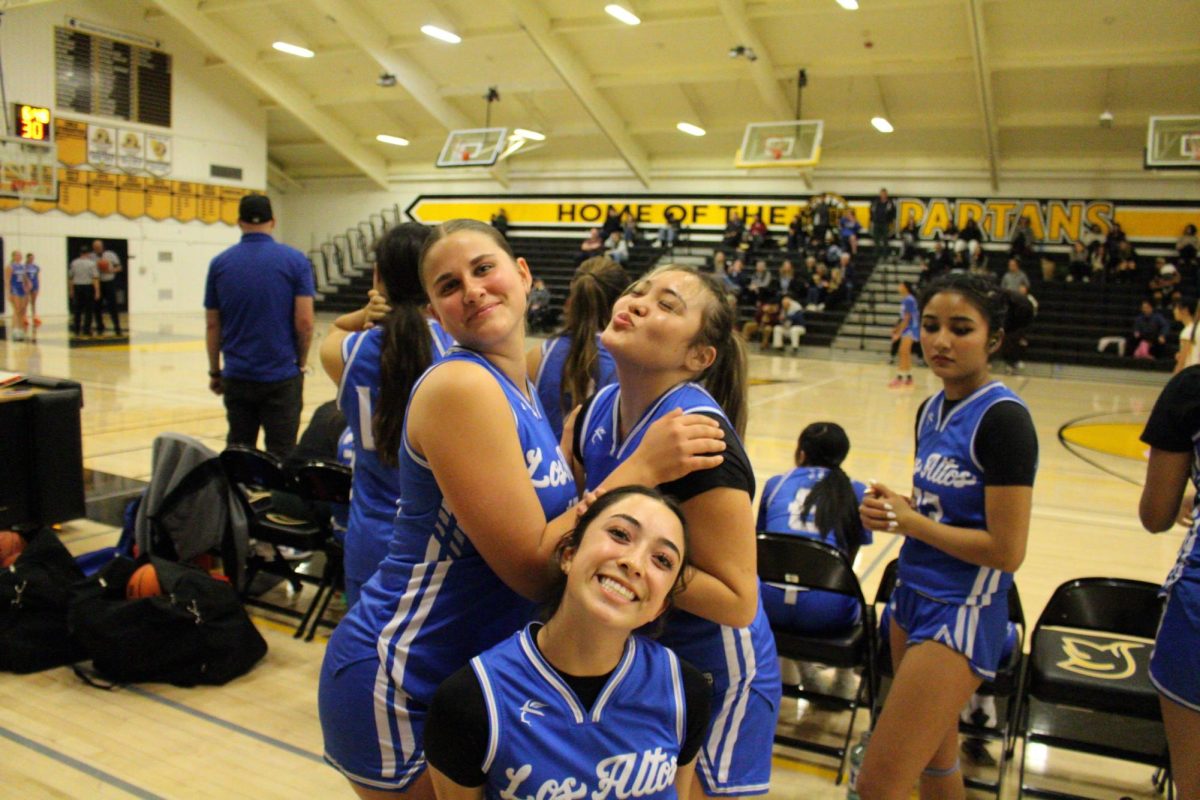 The varsity girls basketball team poses together while watching JV play at an away game against the Mountain View Spartans. 