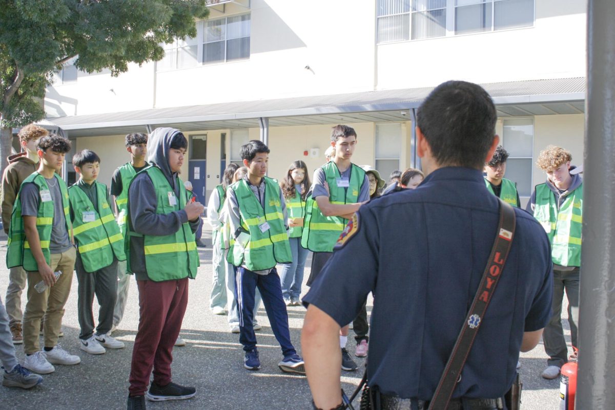 Attendees watch as a firefighter from the City of Los Altos demonstrates how to use a fire extinguisher. 
