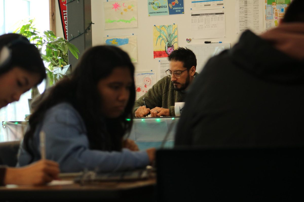 APUSH teacher Ryan Kearney grades a worksheet while students do classwork.