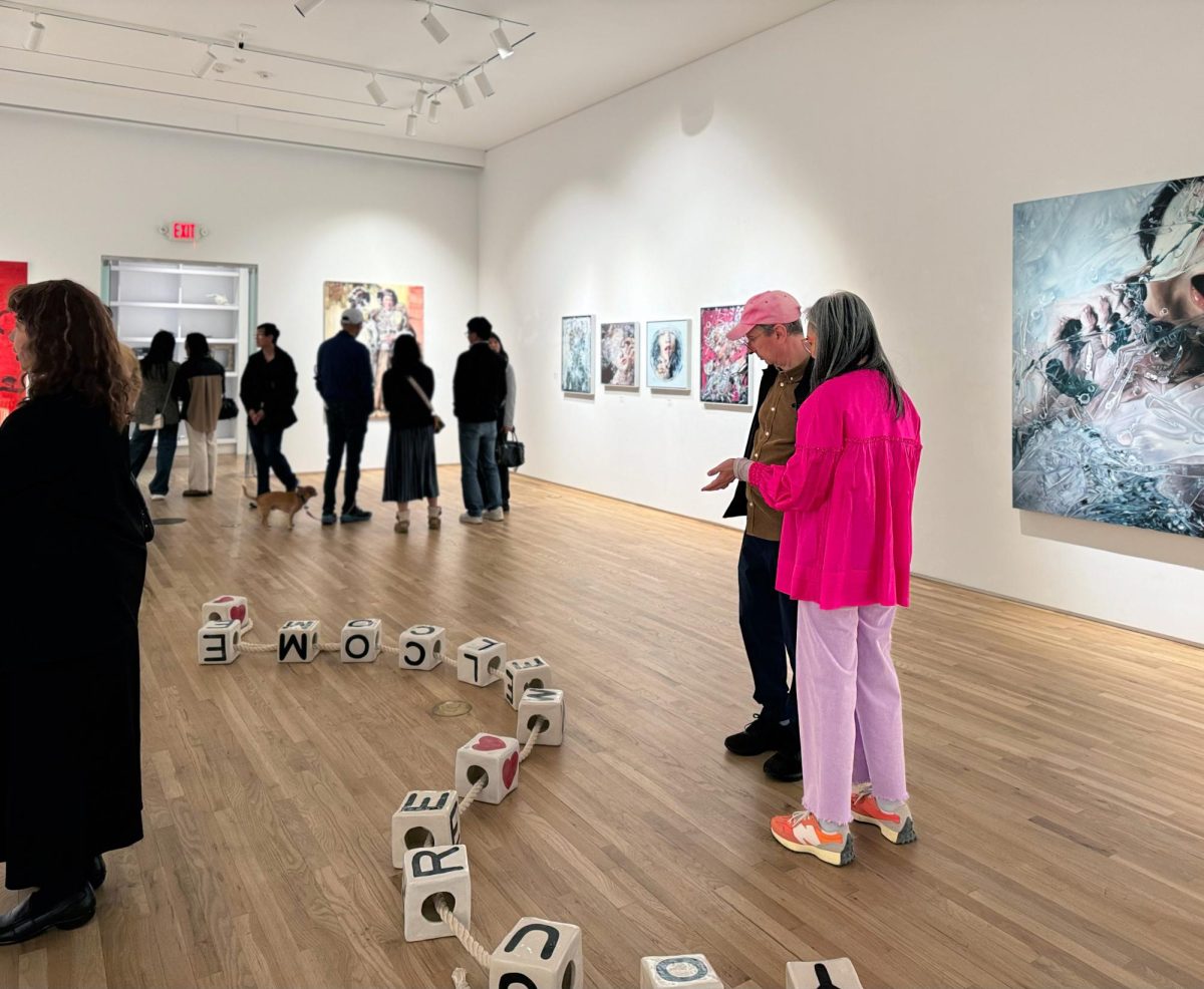 Viewers and artists gather in the gallery on “Our Bodies Through Our Eyes”’s opening reception.