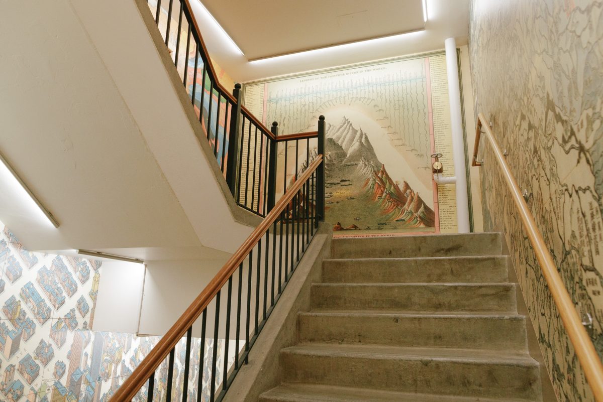 A three-flight stairwell—with maps imprinted on all sides of the walls—leads viewers up to the center.