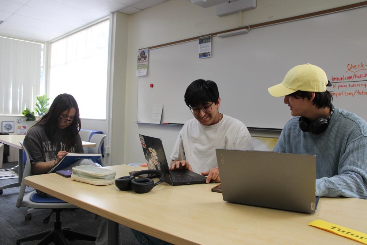 Junior Dylan Brown works with his classmates on their English assignments while another student completes her Drawing assignment. 
