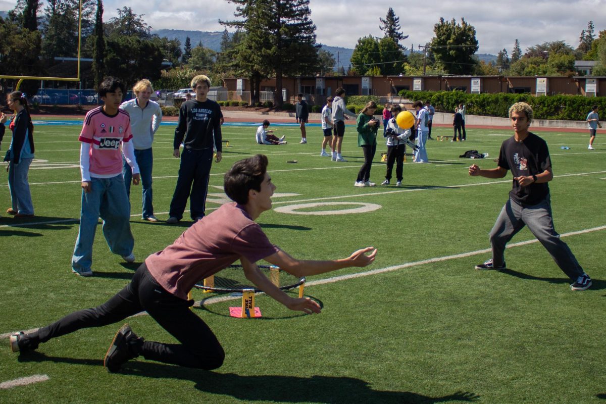 Students competing in ASB’s spikeball tournament dive to prevent the ball from hitting the ground.
