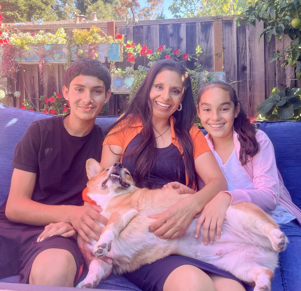 De izquierda a derecha: Andrés Grima-Orozco, alumno de tercer año, su madre María Orozco y su hermana Michelle Grima-Orozco posan con su perra corgi, Dixie. Dixie fue recientemente elegida como la nueva mascota de la biblioteca de Los Altos High School.

